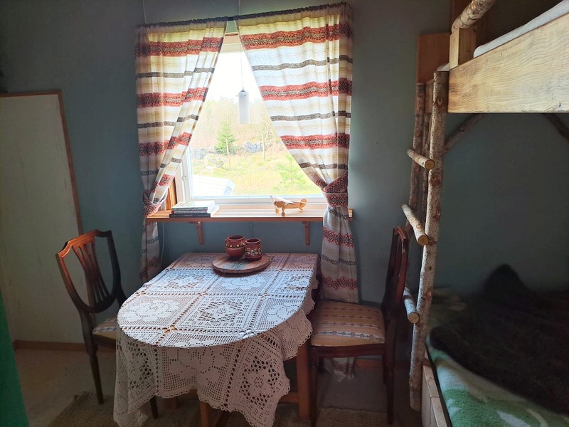 Cabin corner with a table by the window and bunk bed