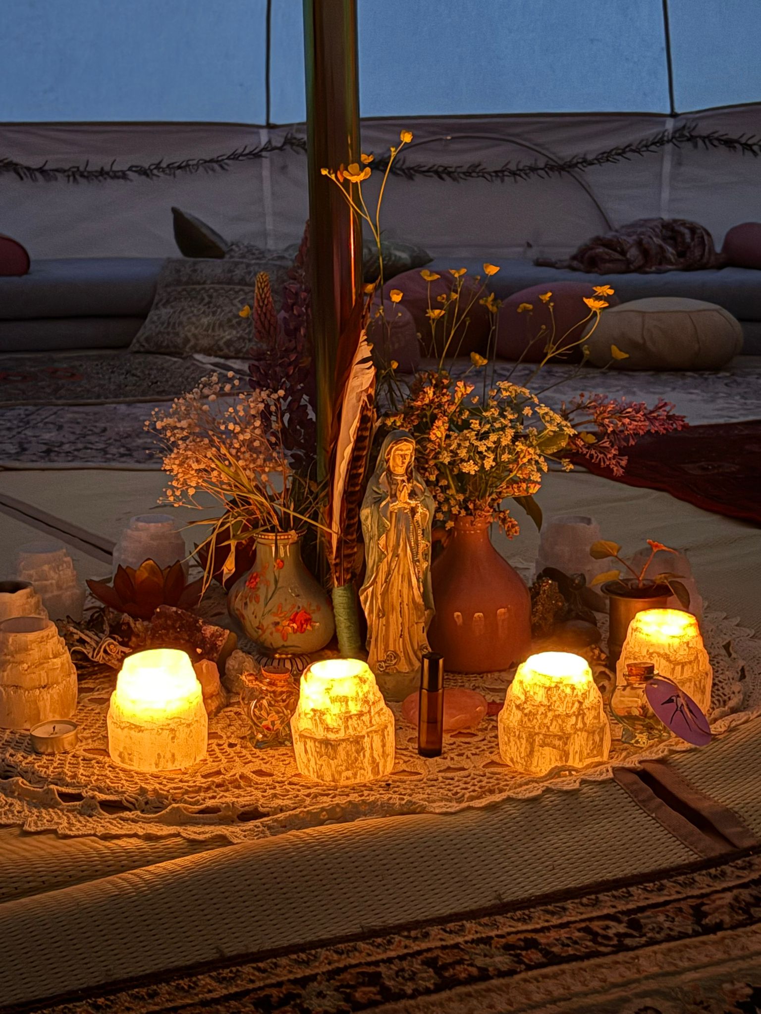 Ceremony altar with candles, flowers and a statue inside the tipi