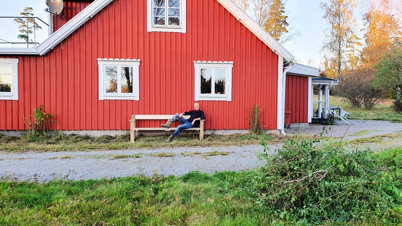 Relaxing on a bench by the big red house