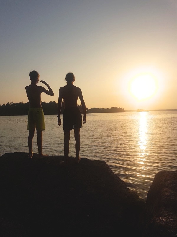 Two boys watching the sunset over the lake