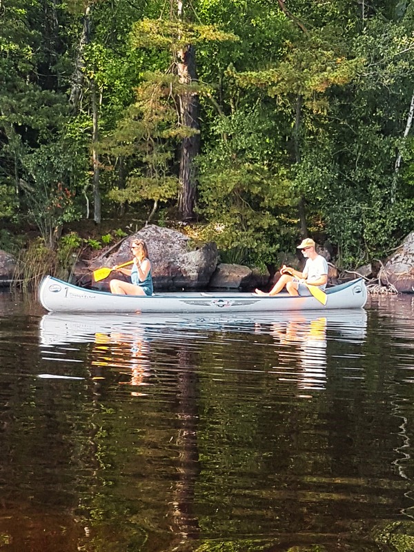 Two people canoeing on a calm lake